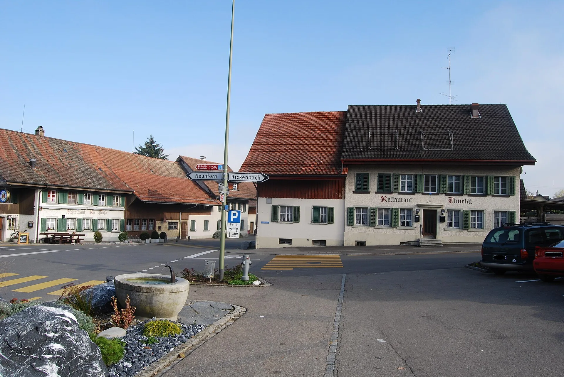 Dorfplatz Altikon mit Brunnen, Wegweiser nach Neunforn und Rickenbach und dem Restaurant Thurtal