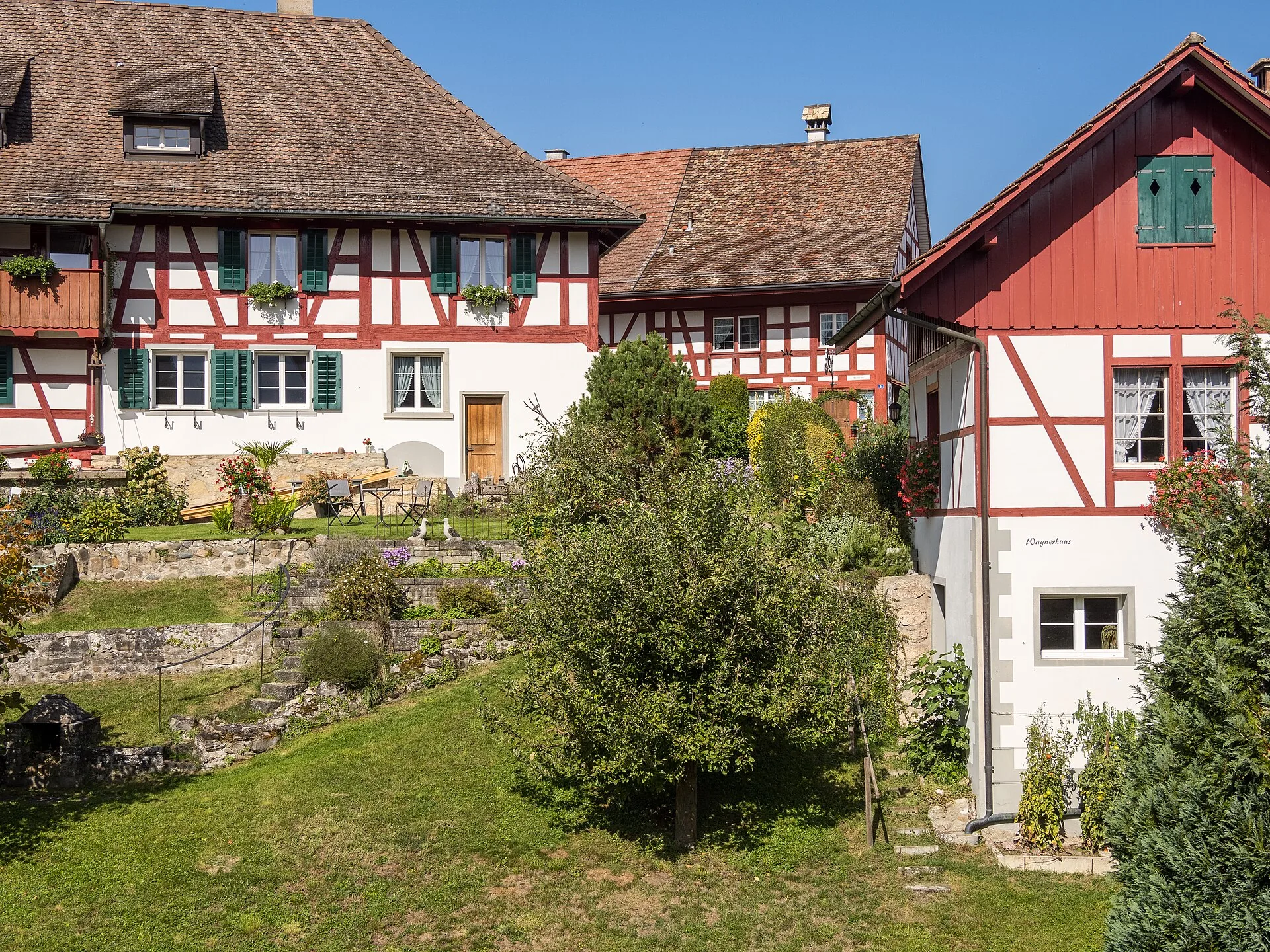 Rote Riegelhäuser am Haldenweg in Berg am Irchel mit Gärten und Trockenmauern
