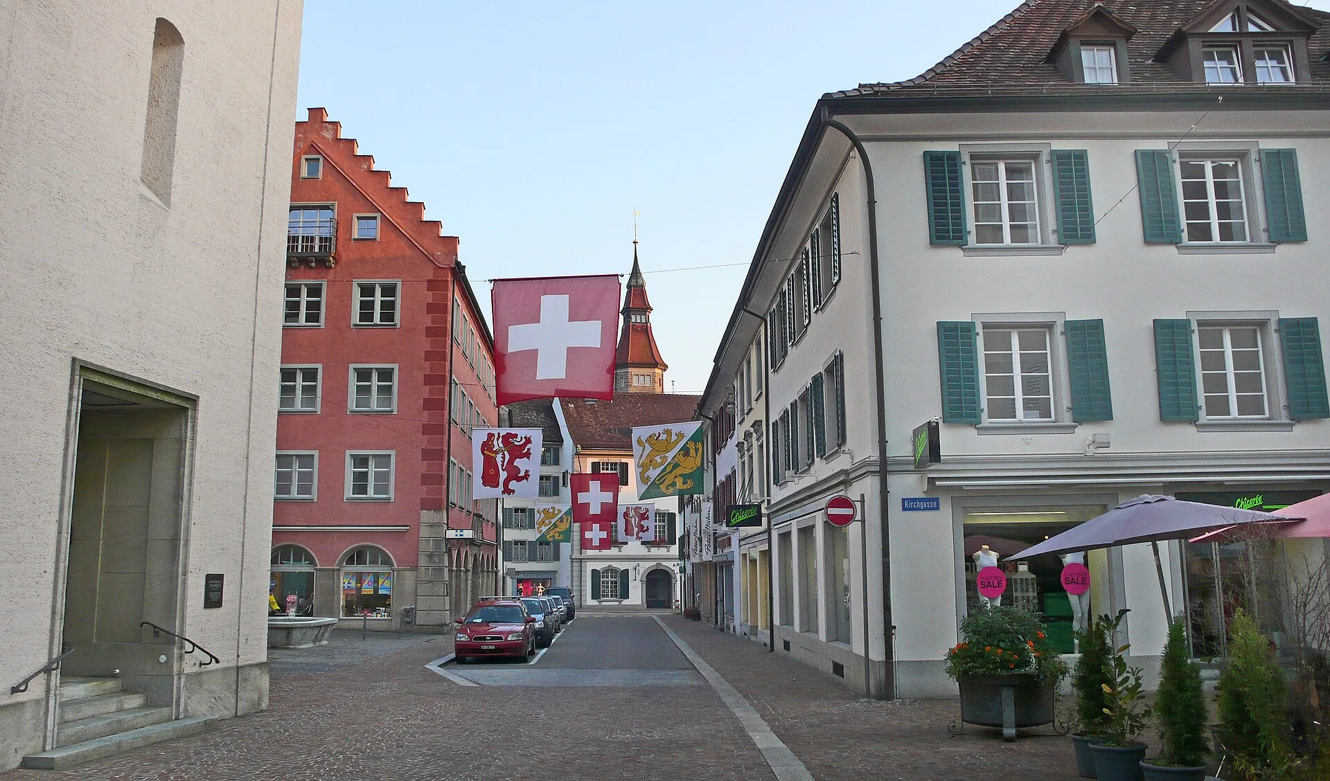 Altstadtgasse in Frauenfeld mit Schweizer und Thurgauer Fahnen und dem Rathausturm im Hintergrund