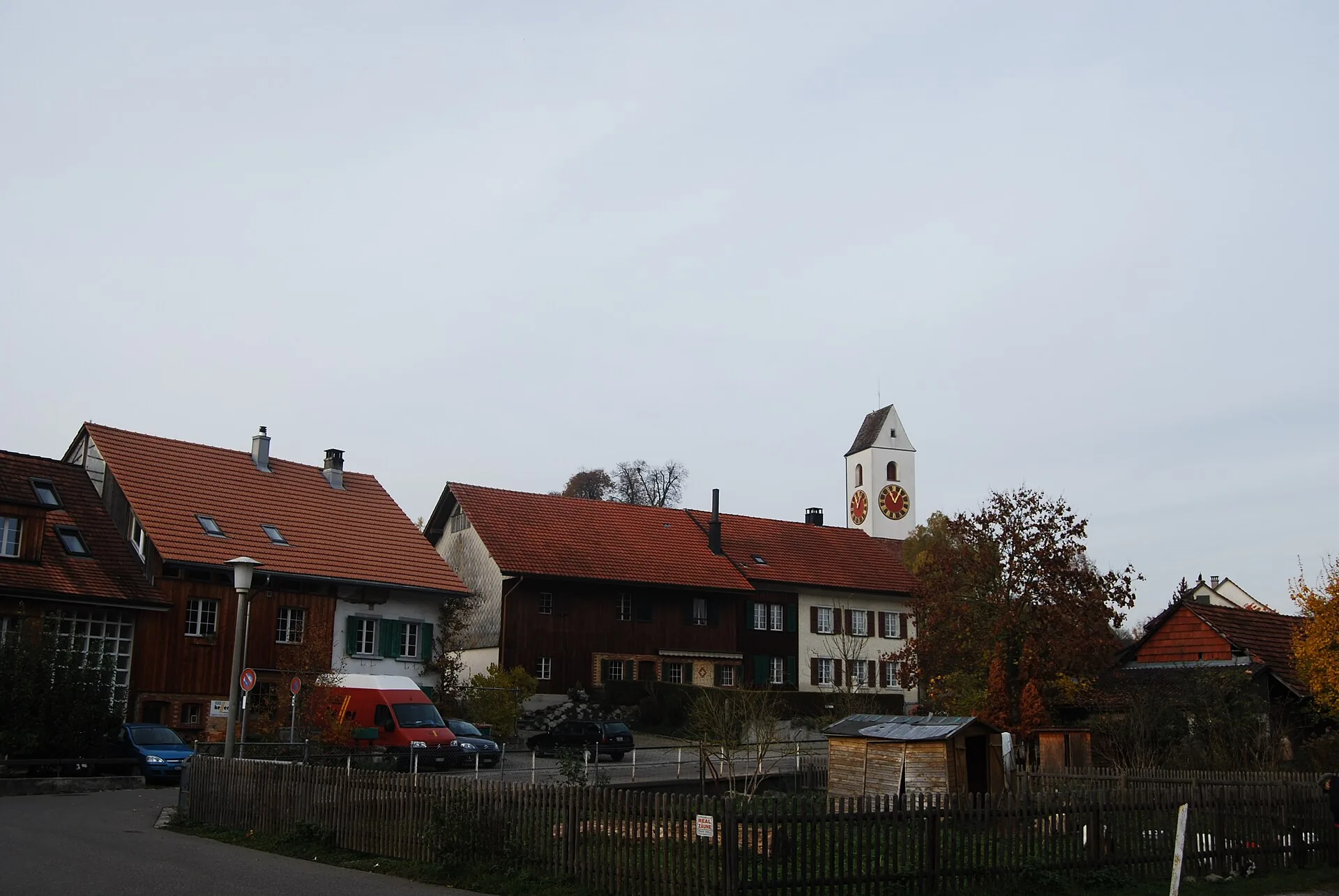 Dorfstrasse in Hettlingen mit Bauernhäusern und dem Kirchturm im Hintergrund im Herbst