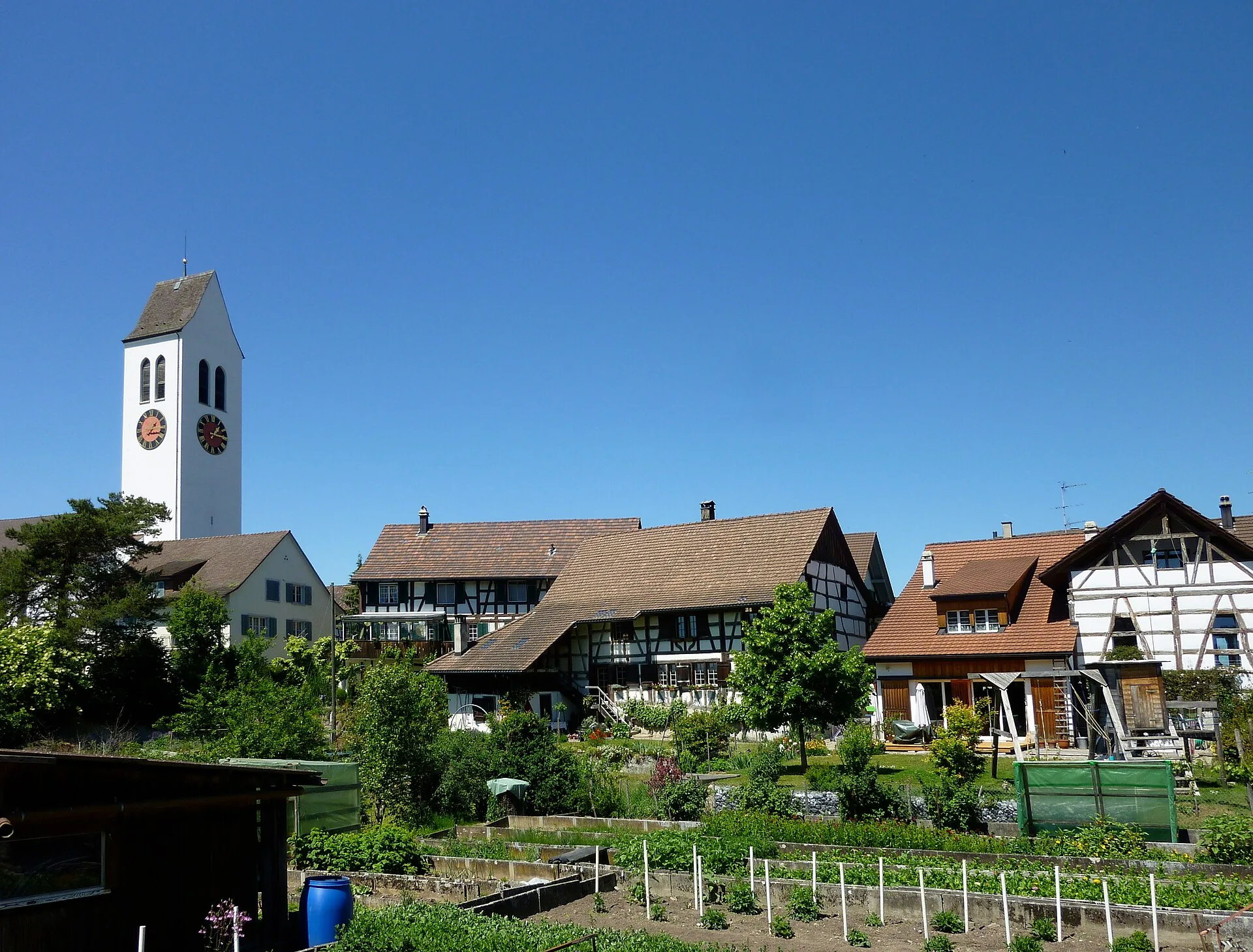Kirchturm von Ossingen mit Riegelhäusern und Gemüsegärten im Dorfkern