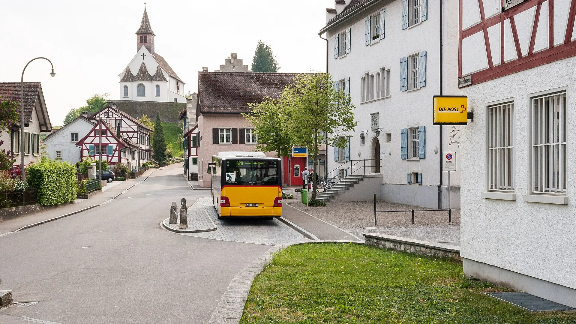 Poststrasse in Rheinau mit Postauto, Riegelhäusern und Bergkirche